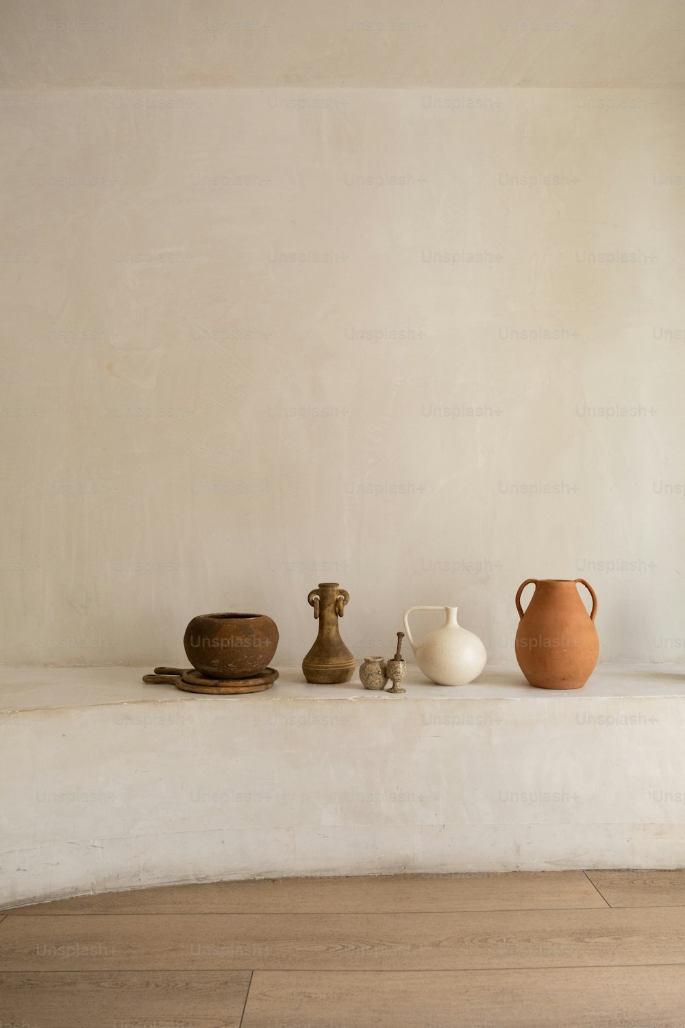 une table surmontée de vases et de bols sur un plancher en bois