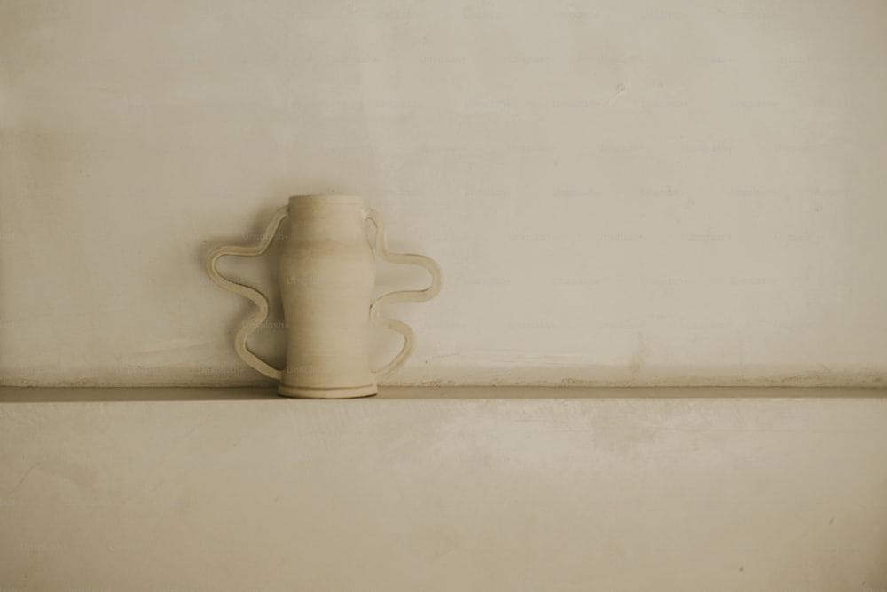 un vase blanc posé sur une étagère