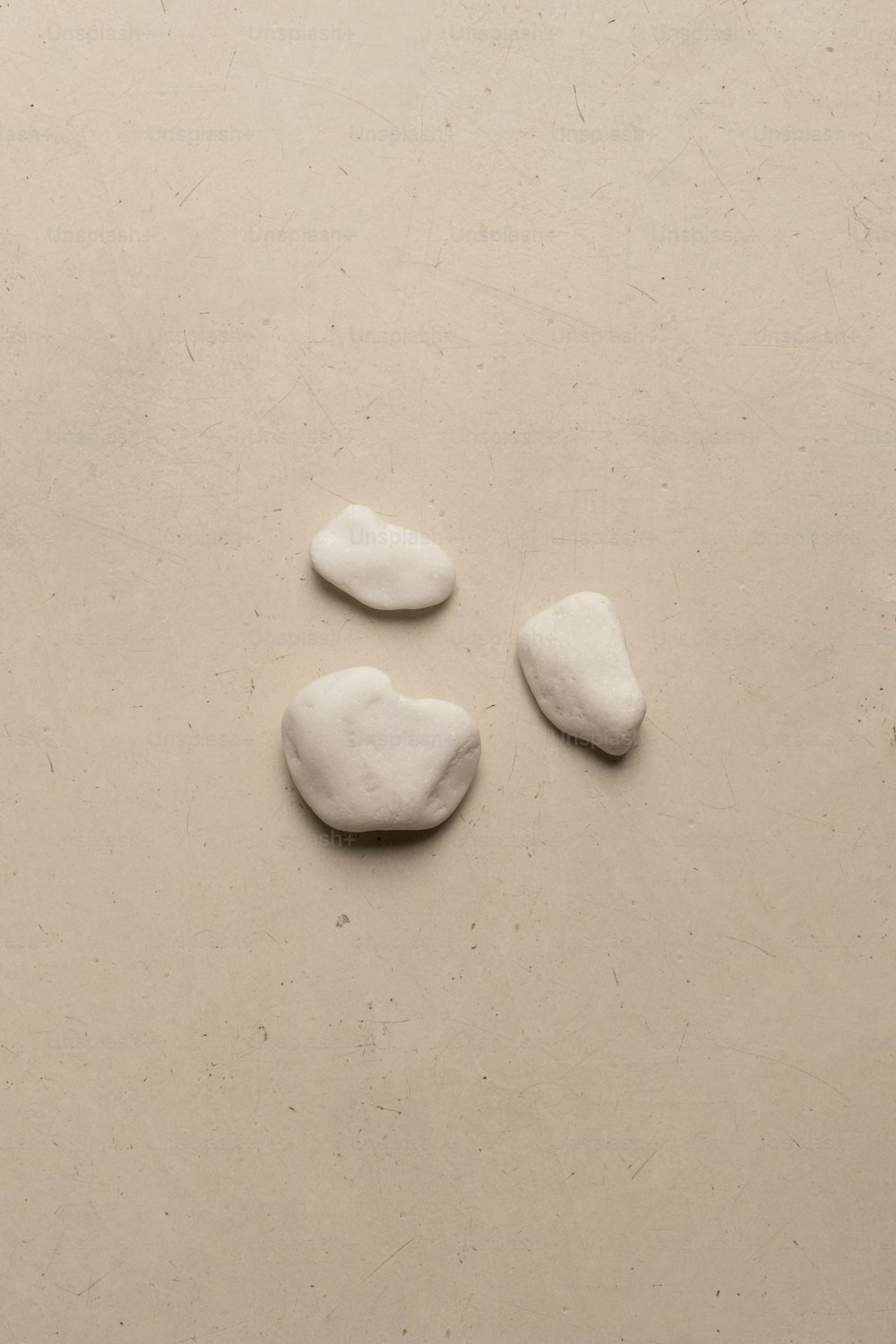tre rocce bianche che si siedono sopra un tavolo