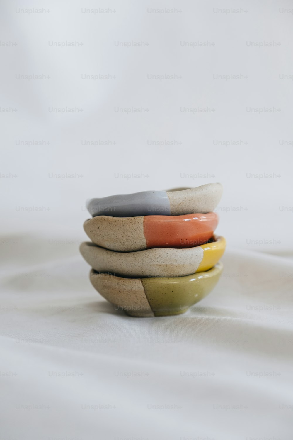 a stack of three bowls sitting on top of a bed