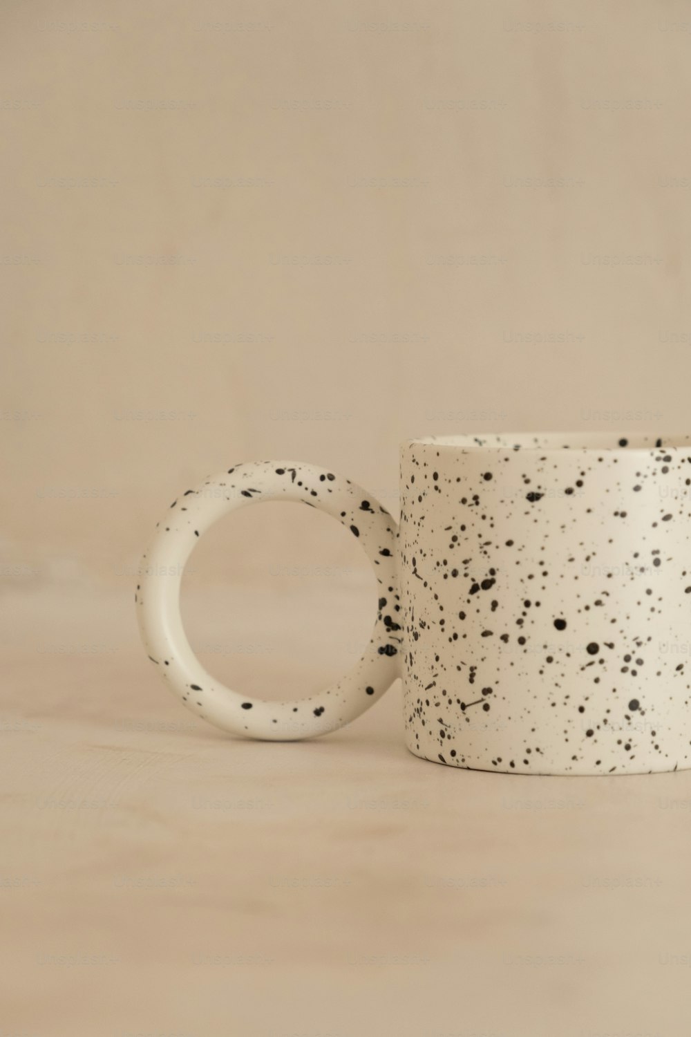 a white coffee mug with black speckles on it