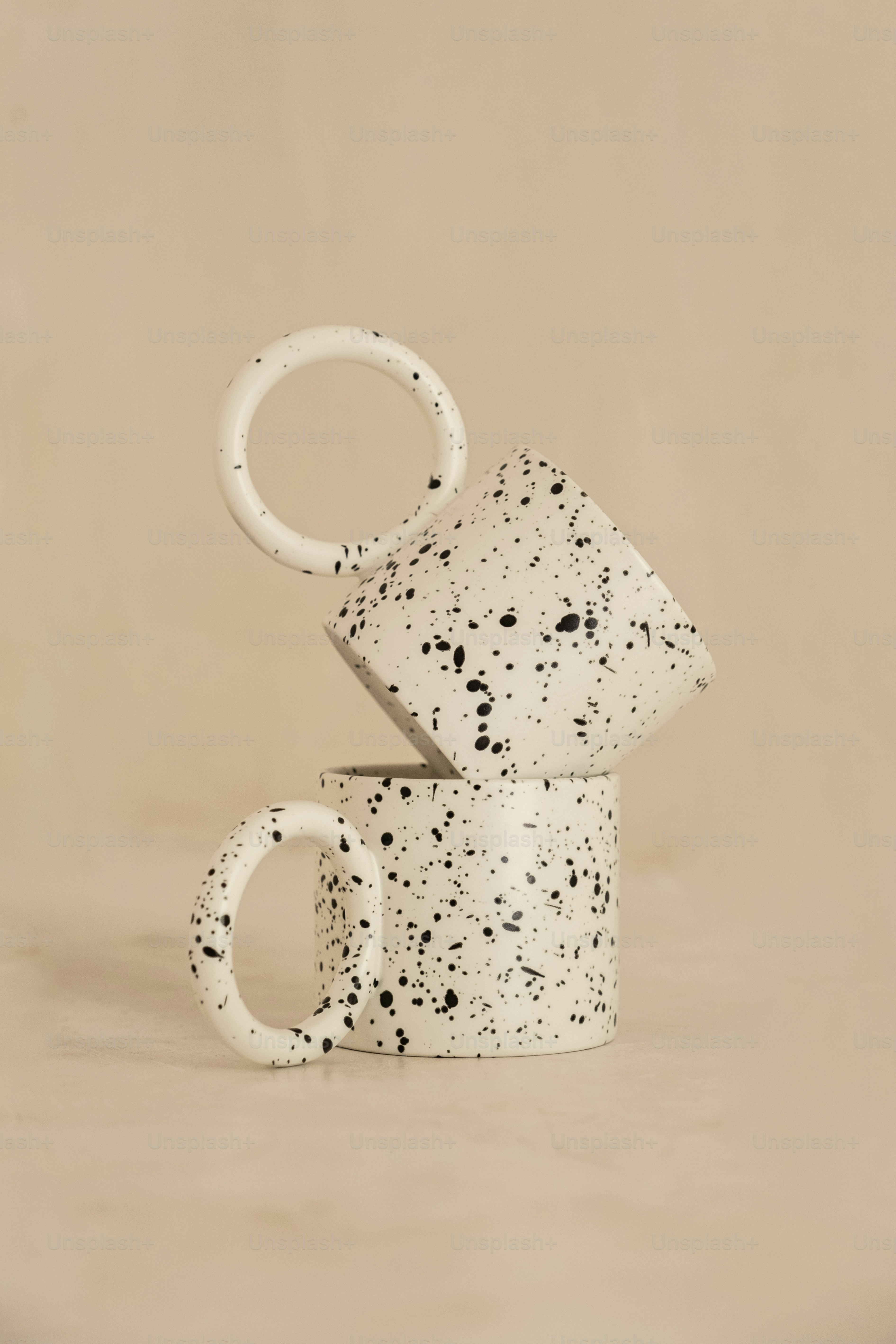 two coffee mugs stacked on top of each other