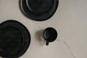 Un par de platos negros encima de una mesa