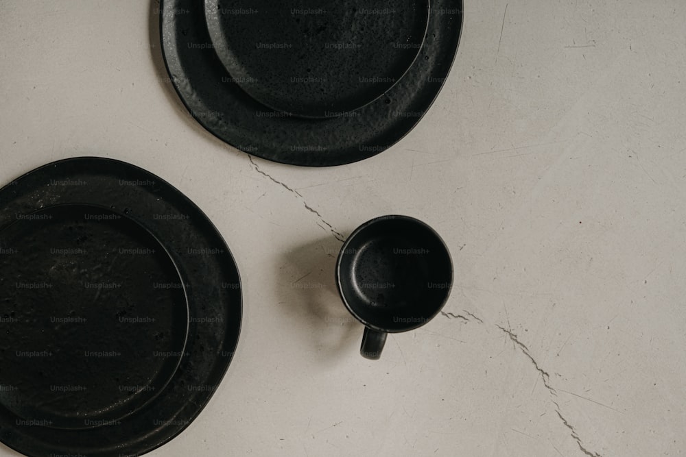 a couple of black plates sitting on top of a table