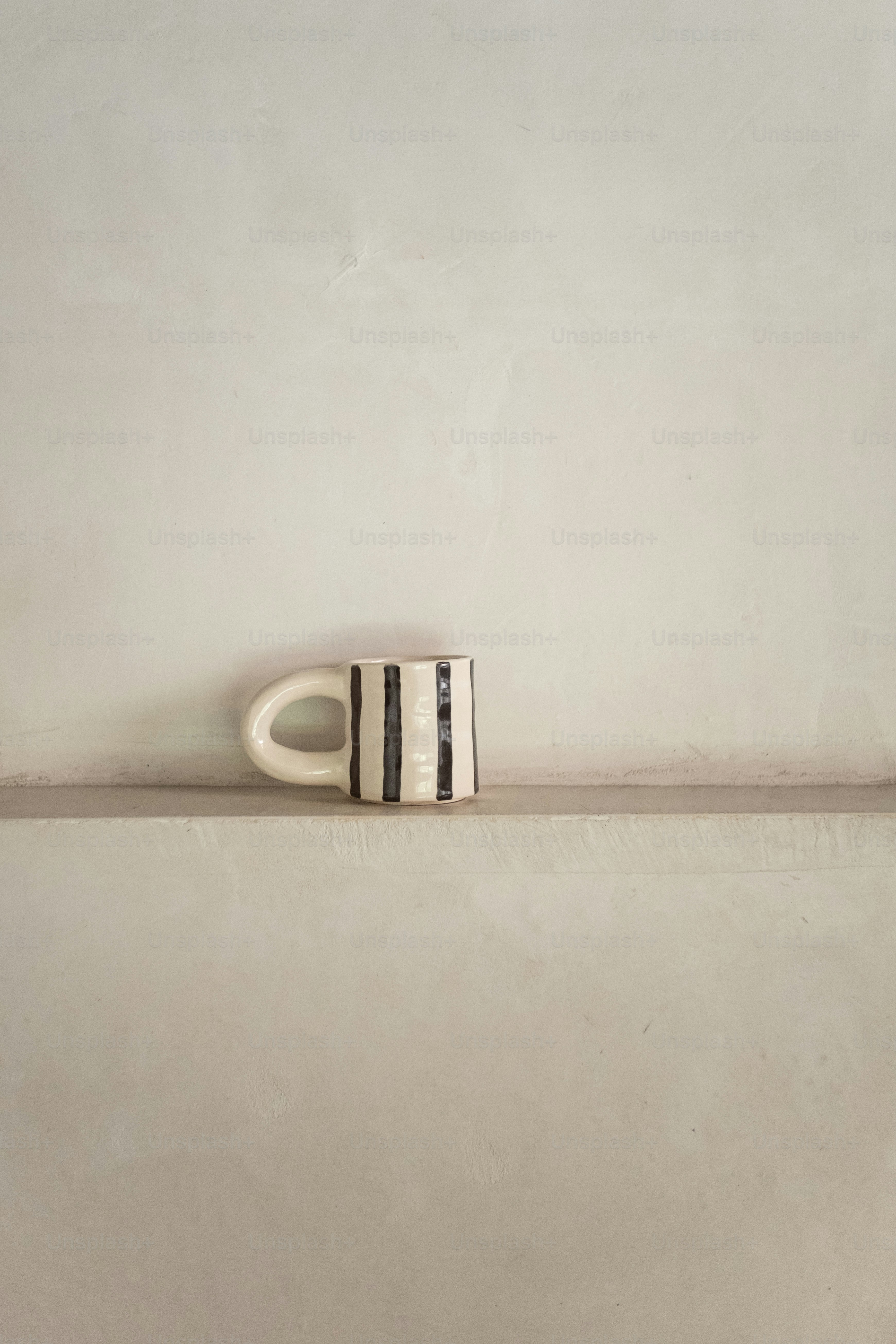a black and white vase sitting on top of a shelf