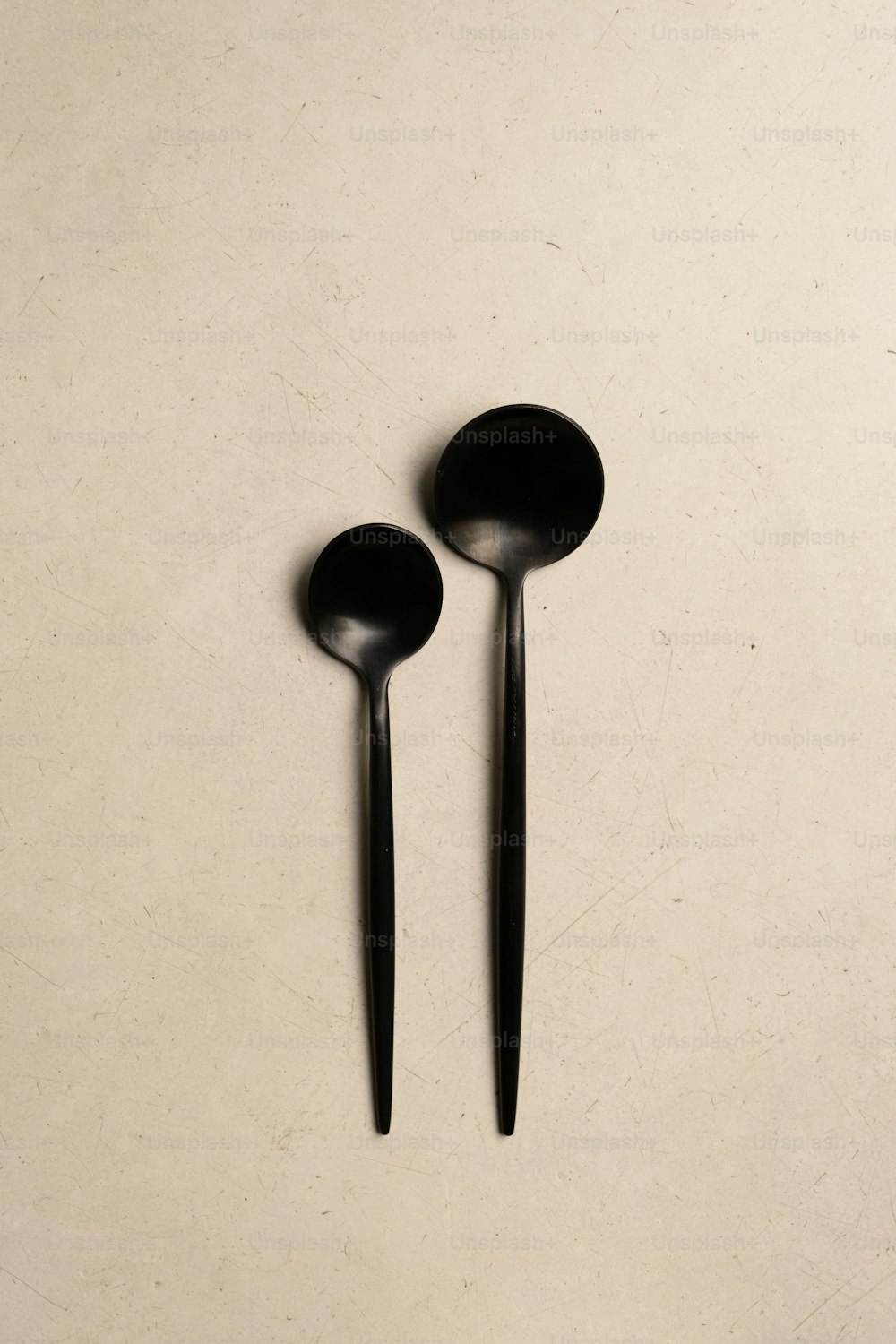 a couple of black spoons sitting on top of a table