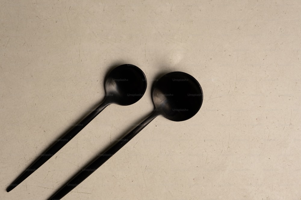 a couple of black spoons sitting on top of a table