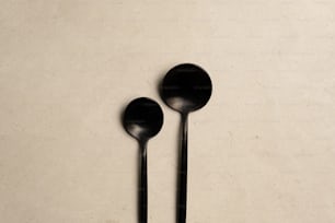 a couple of black spoons sitting on top of a table