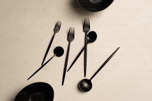 a table topped with black utensils and black plates