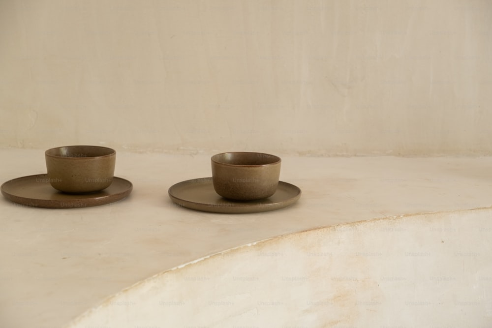 two cups and saucers sitting on a table