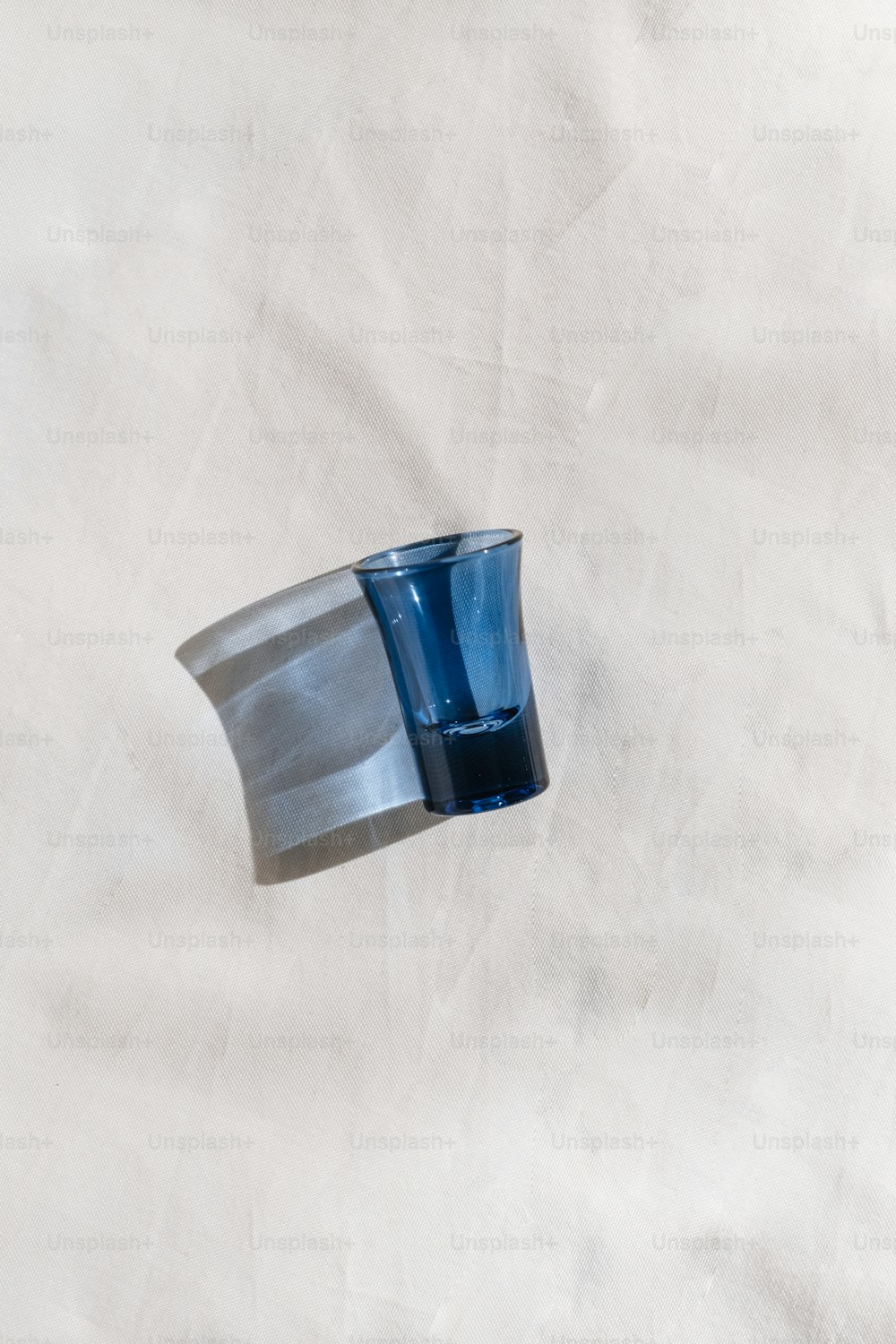 a blue glass sitting on top of a white table