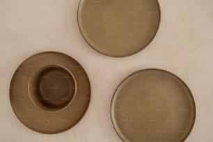 three brown plates sitting on top of a white counter