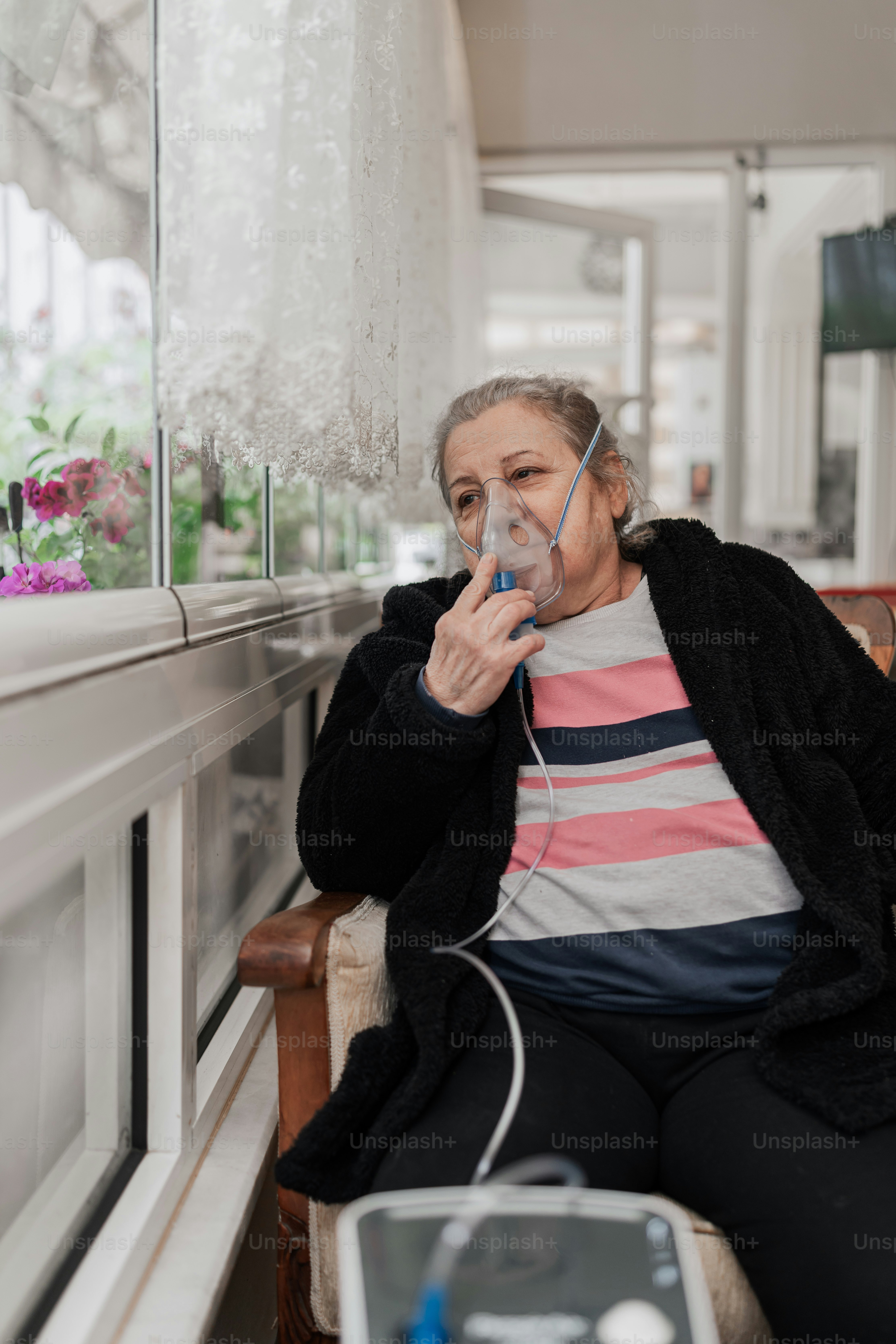una mujer sentada en una silla con un secador de pelo en la mano