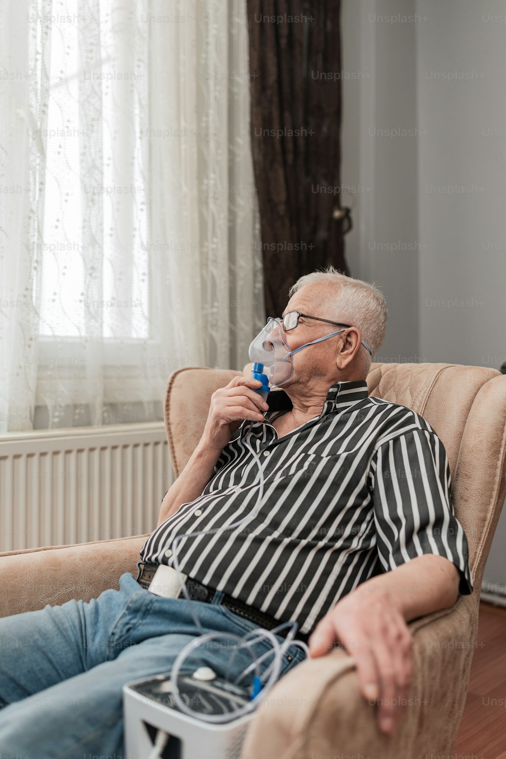 a man sitting in a chair drinking from a water bottle