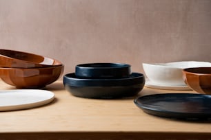 a table topped with plates and bowls on top of a wooden table