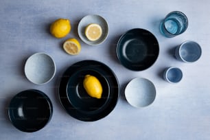 a table topped with plates and bowls filled with lemons