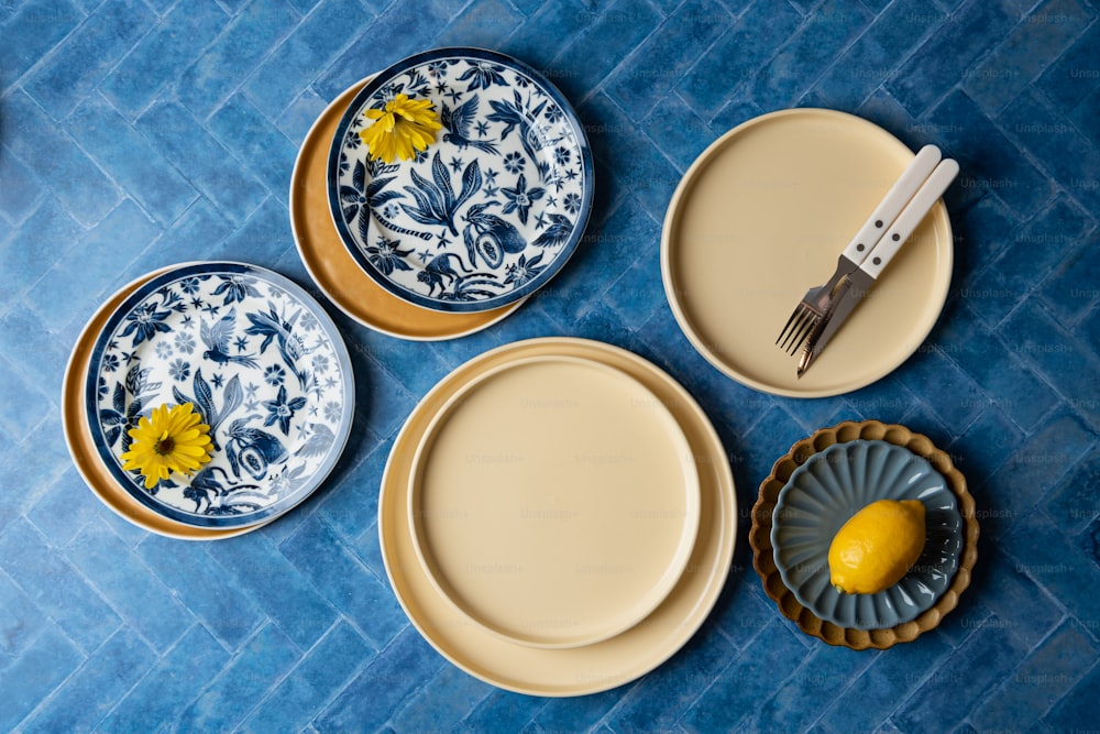 a table topped with plates and a lemon next to a knife and fork