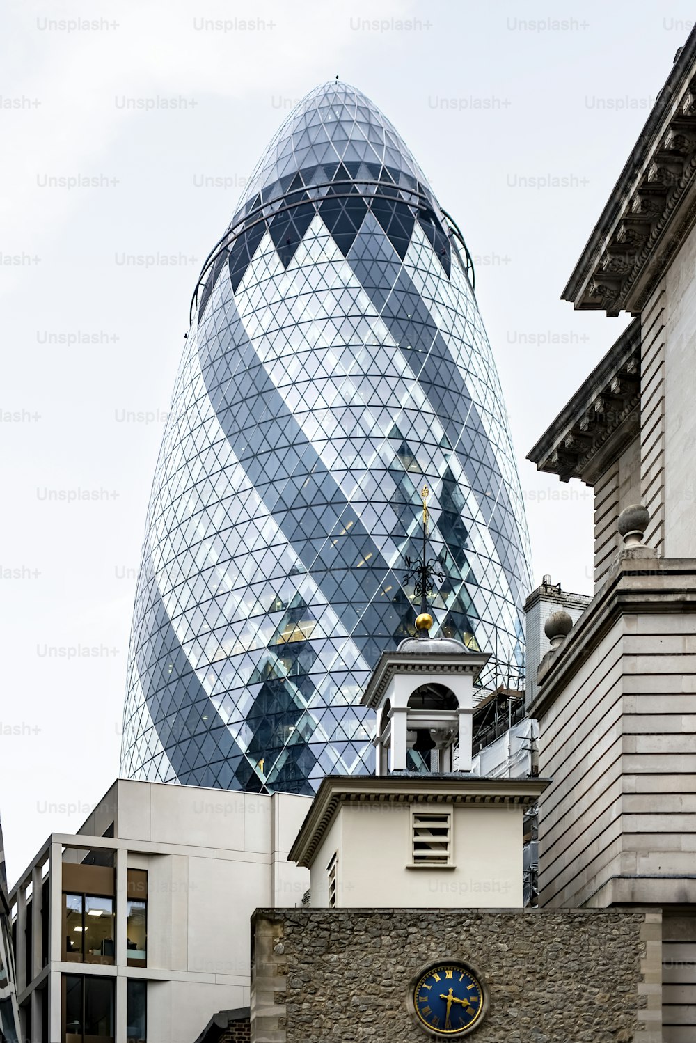 a tall glass building with a clock on it's side