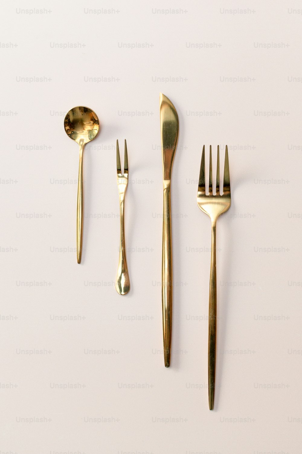 a set of three forks and two spoons