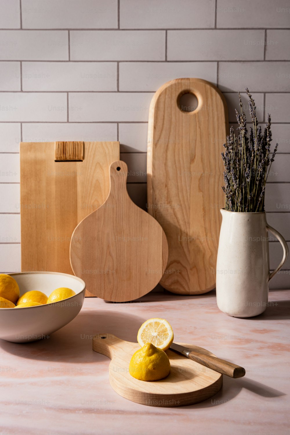 a bowl of lemons and a cutting board on a table