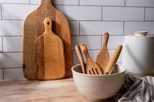 a bowl of wooden utensils and a cutting board