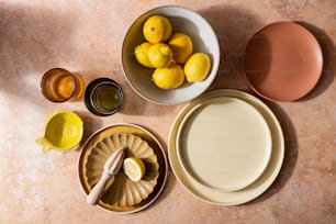 a table topped with plates and bowls filled with lemons