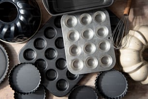 a muffin tin with some cupcakes and a whisk