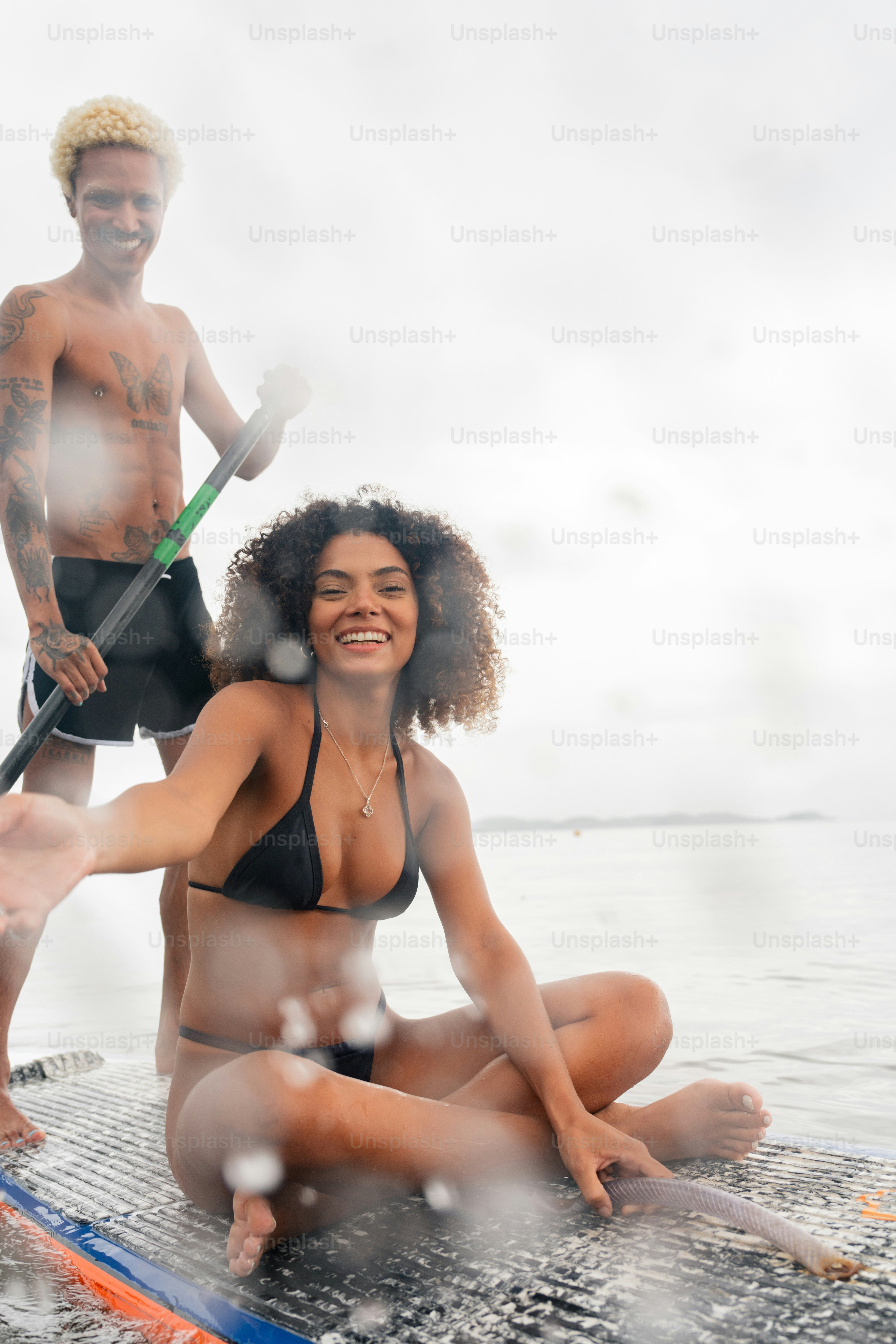 a man and a woman on a surfboard in the water