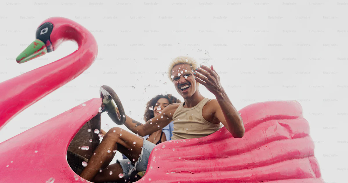Flamingo Ride A couple of people riding a pink flamingo ride photo – Summer Image on ...