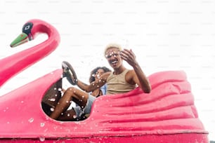 a couple of people riding a pink flamingo ride