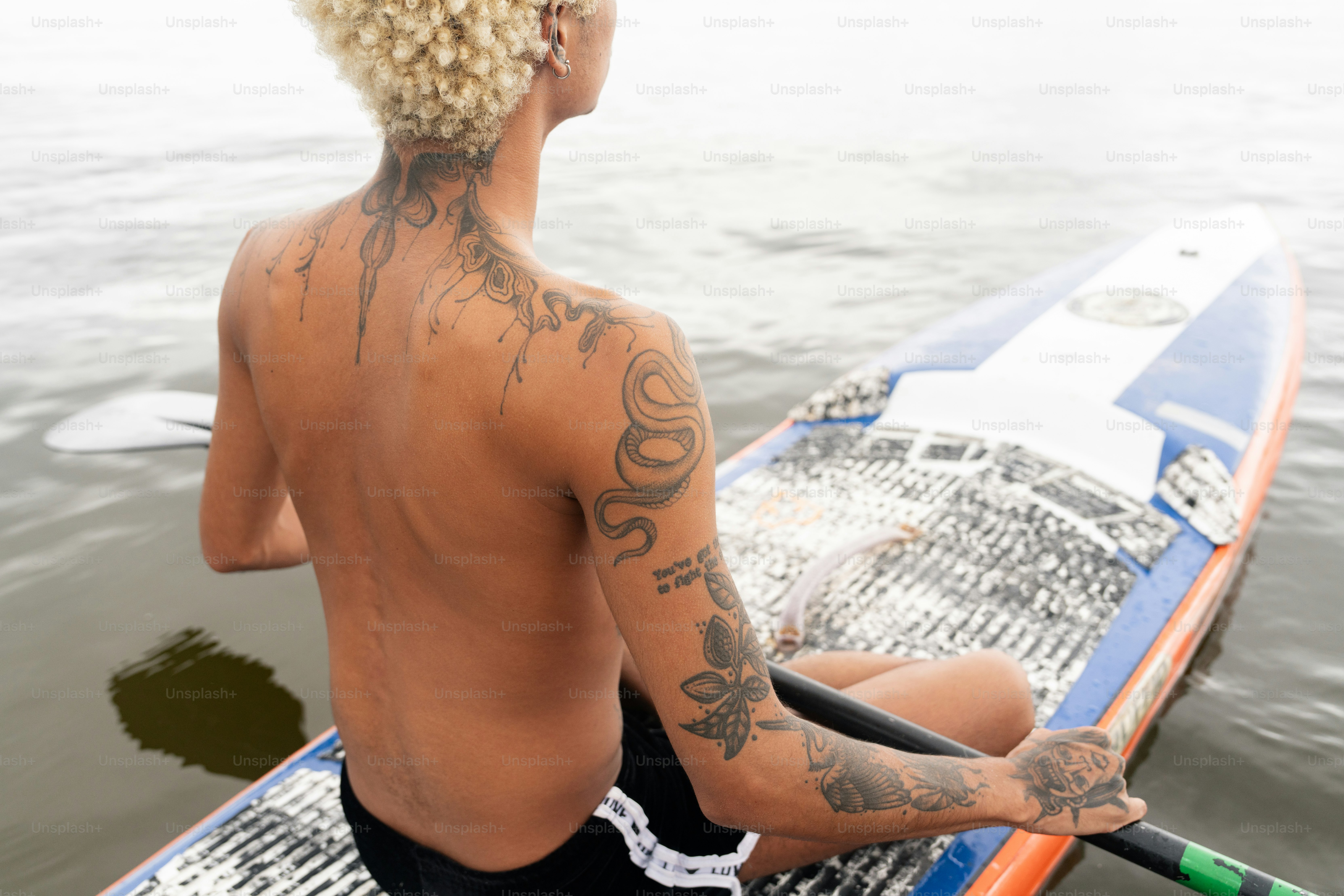ein Mann sitzt auf einem Surfbrett im Wasser