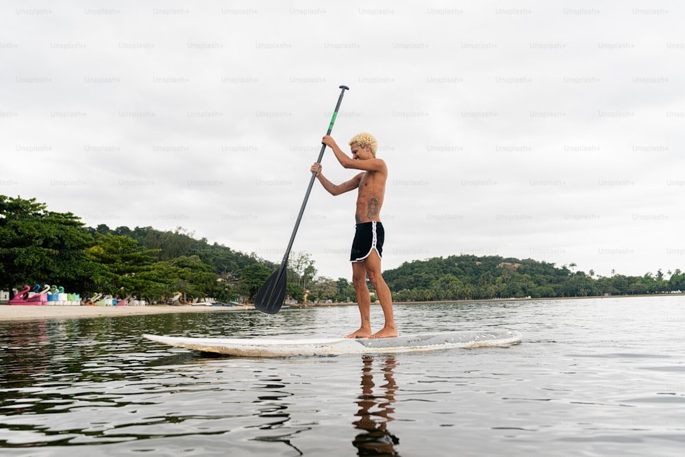 a man standing on a paddle board in the water
