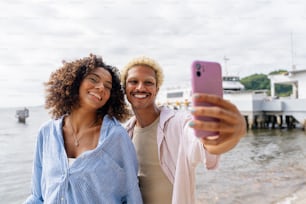 Un hombre y una mujer tomándose una foto con un teléfono celular