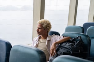 a man sitting in a blue chair next to a window