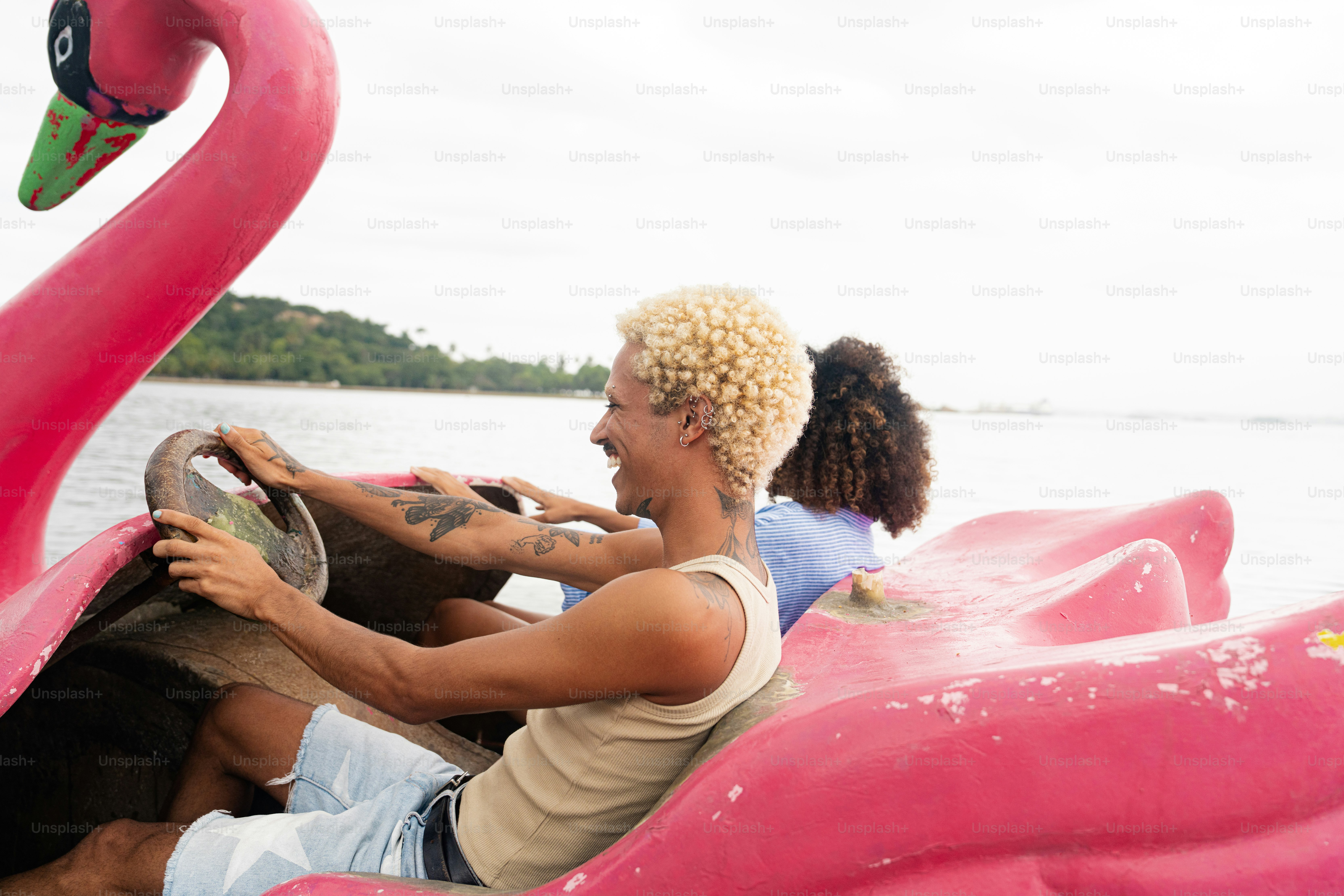 Un uomo che guida una barca di fenicotteri rosa su un lago