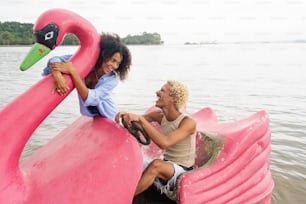 a man and a woman sitting on a pink boat