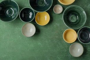 a group of bowls sitting on top of a green table