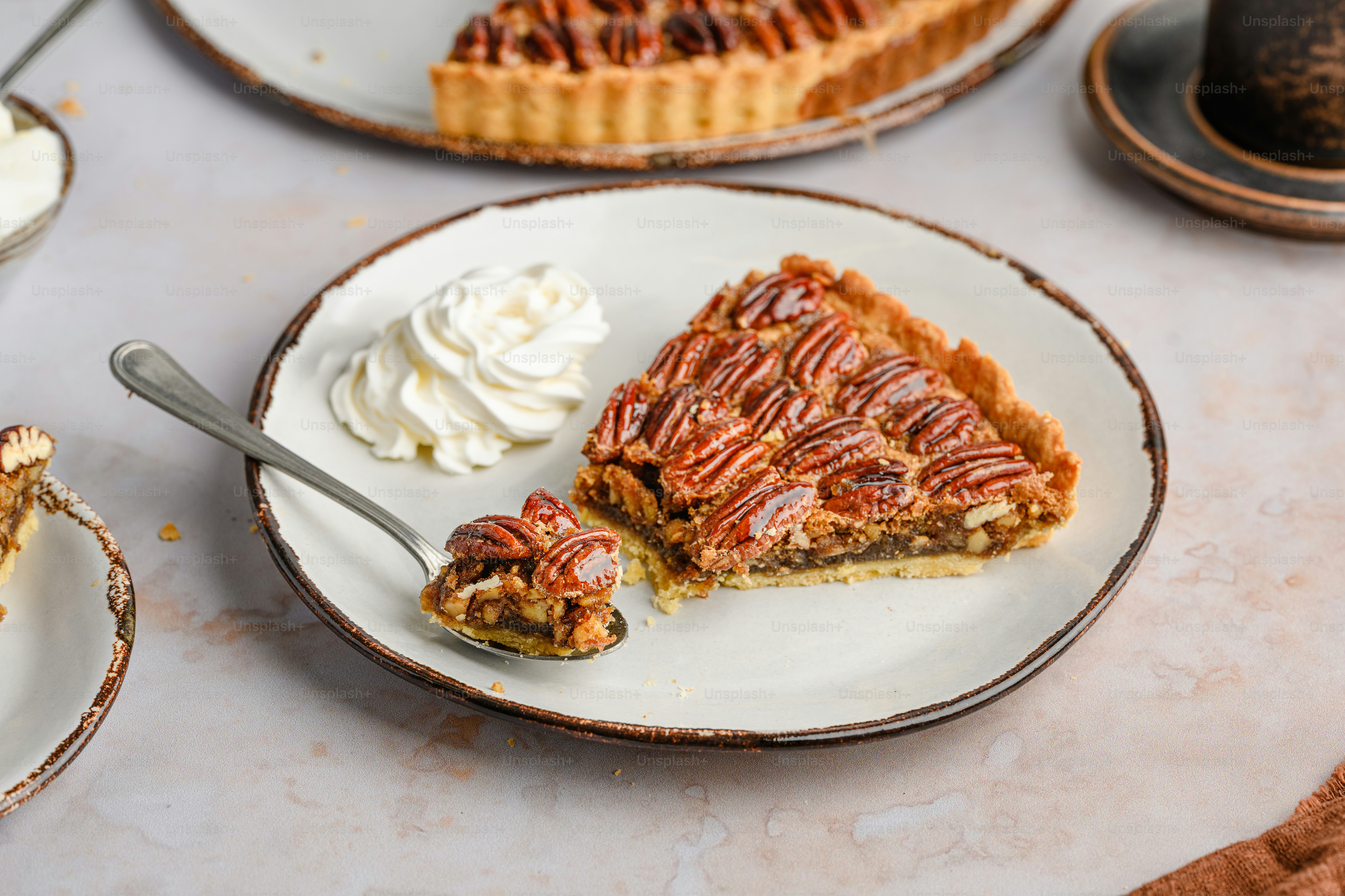 uma fatia de torta de noz pecã em um prato com chantilly