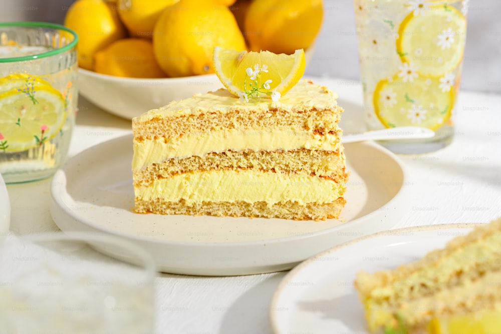 a slice of cake on a plate with lemons in the background