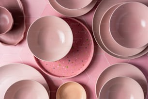 uma mesa coberta com pratos e tigelas cor-de-rosa