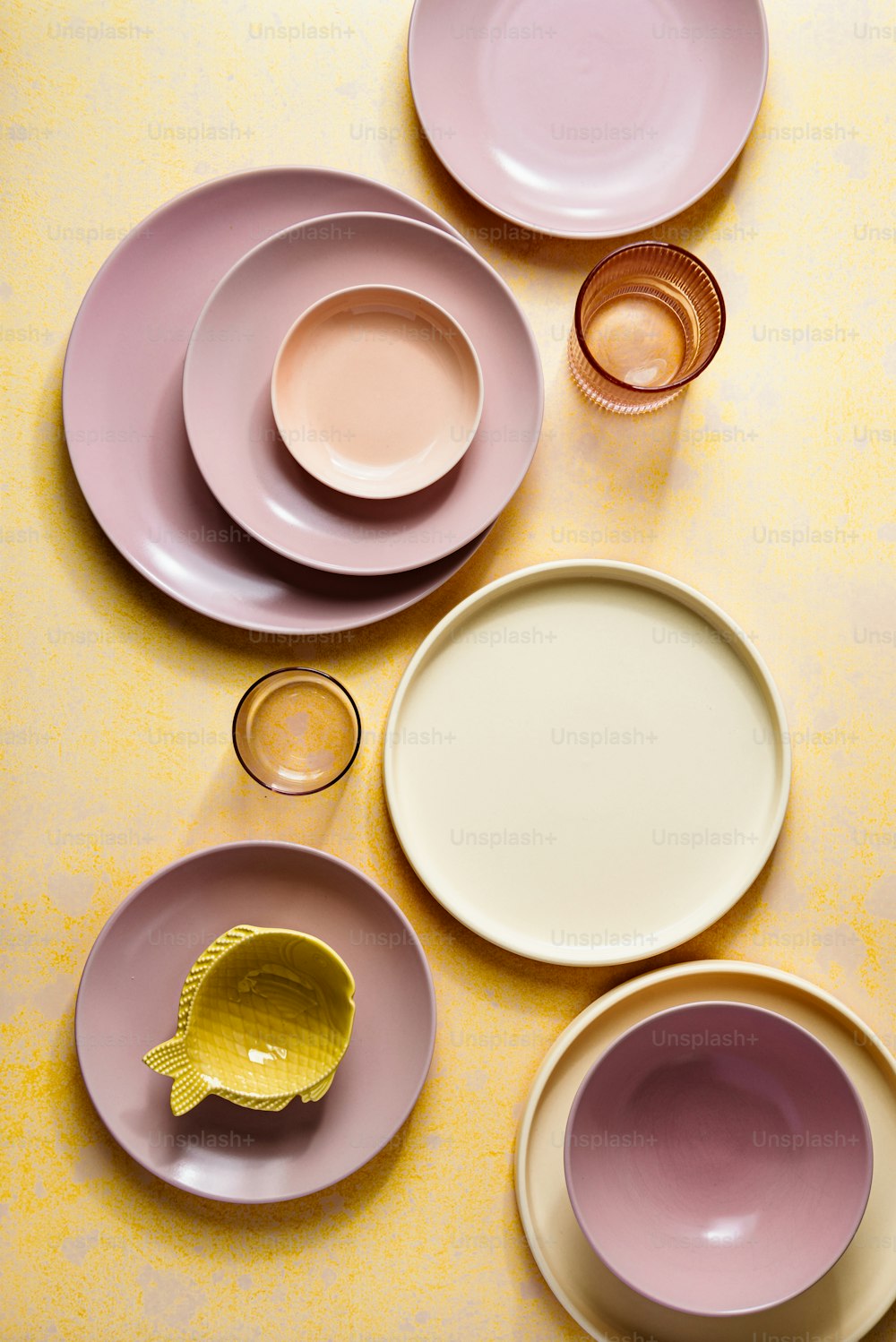 Ein Tisch mit vielen verschiedenfarbigen Tellern