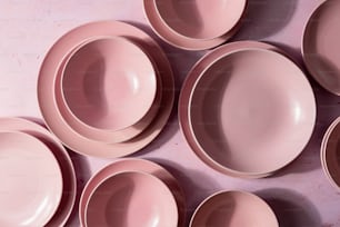 um grupo de pratos cor-de-rosa sentados em cima de uma mesa