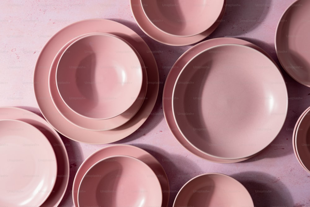 a group of pink plates sitting on top of a table