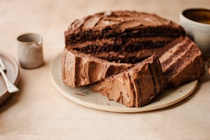 un gâteau au chocolat posé sur une assiette à côté d’une tasse de café