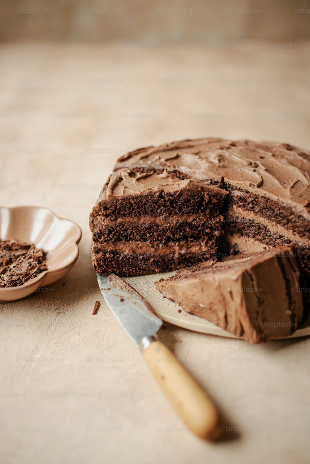 a piece of chocolate cake on a plate next to a knife