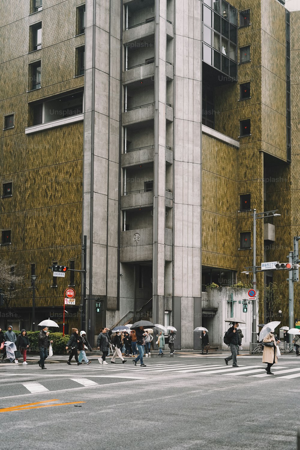 Eine Gruppe von Menschen überquert eine Straße vor einem hohen Gebäude