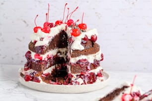 a chocolate cake with cherries and whipped cream