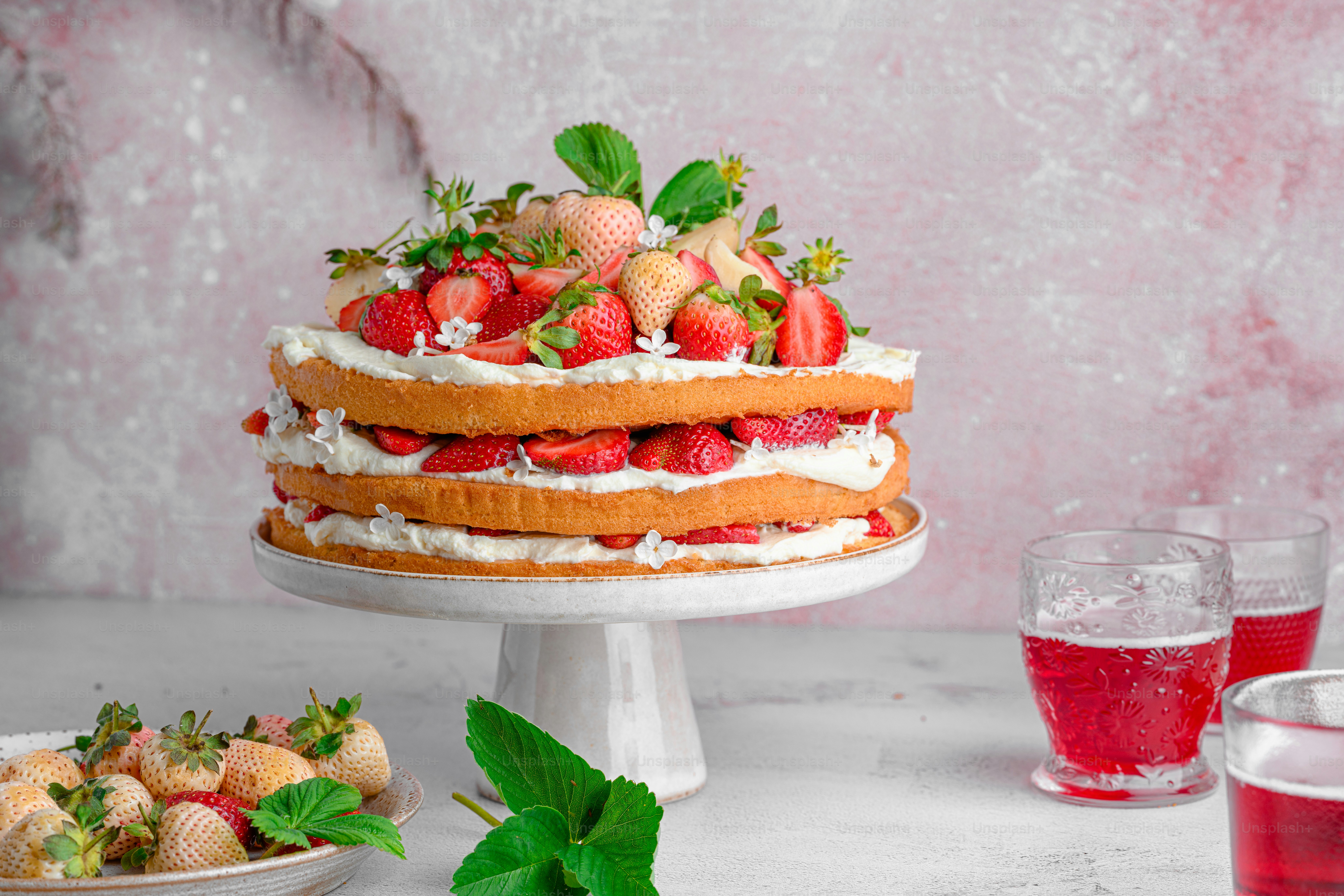 A cake with strawberries and whipped cream on top photo – Layered cake ...