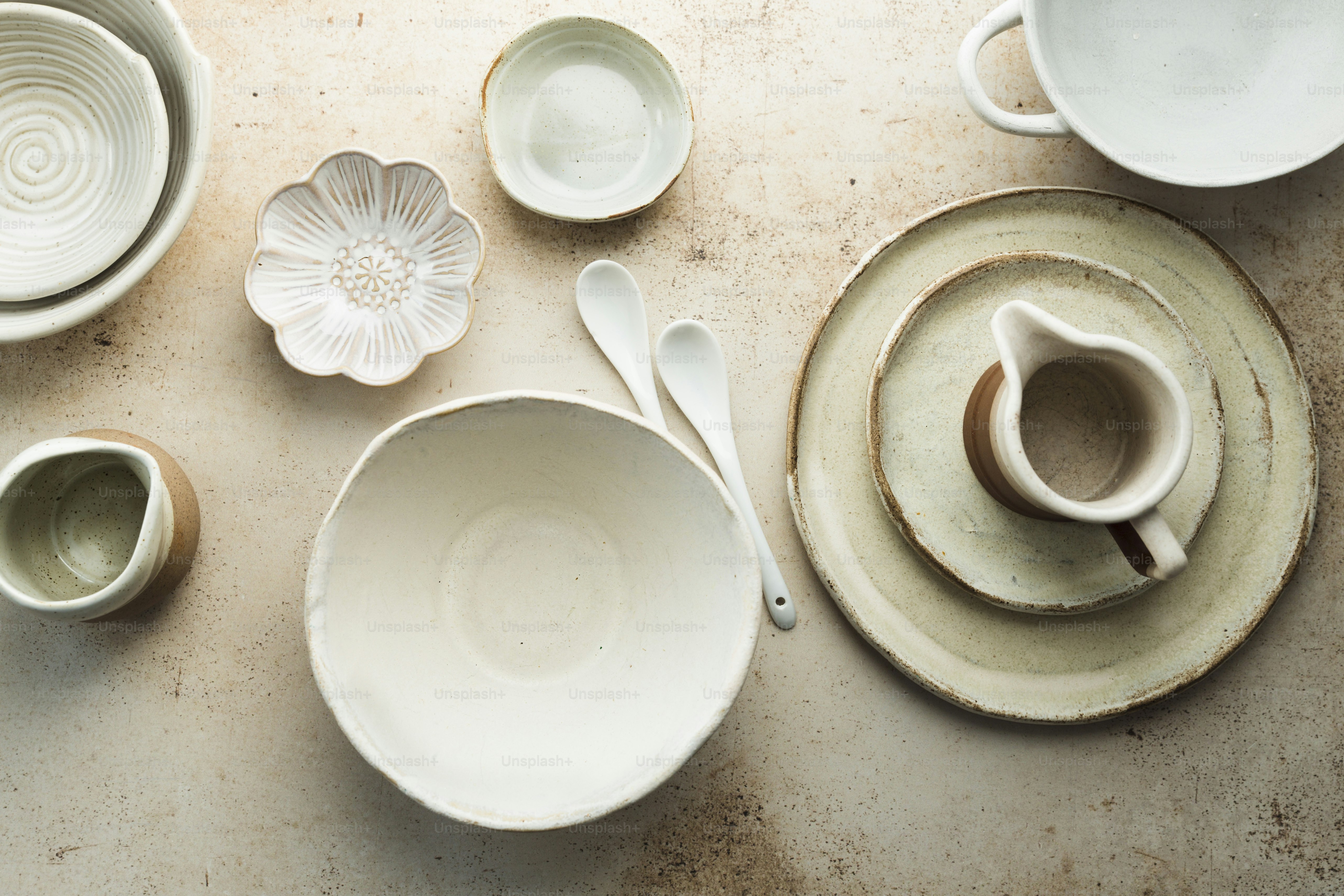 a table topped with white dishes and cups
