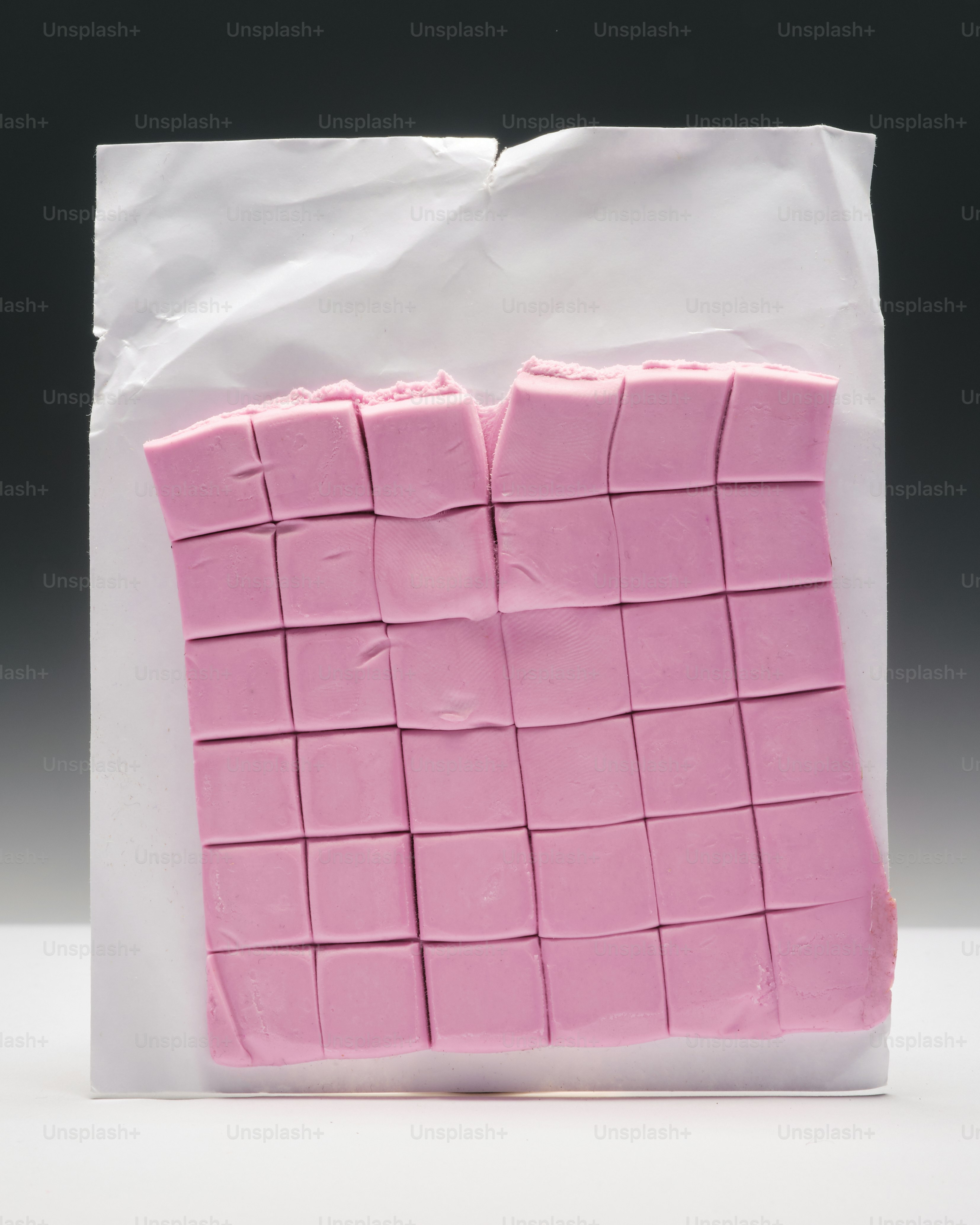 Ein Stück rosa Kuchen sitzt auf einer weißen Tüte